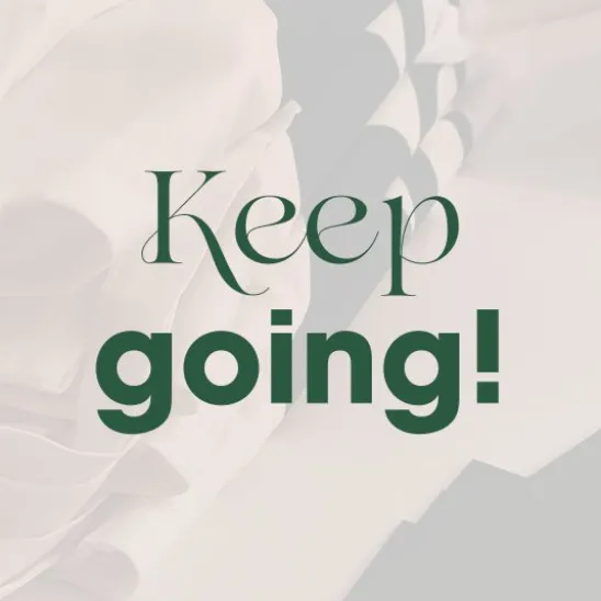 „Keep going!“ – Schriftzug über hellem Geschenkpapier