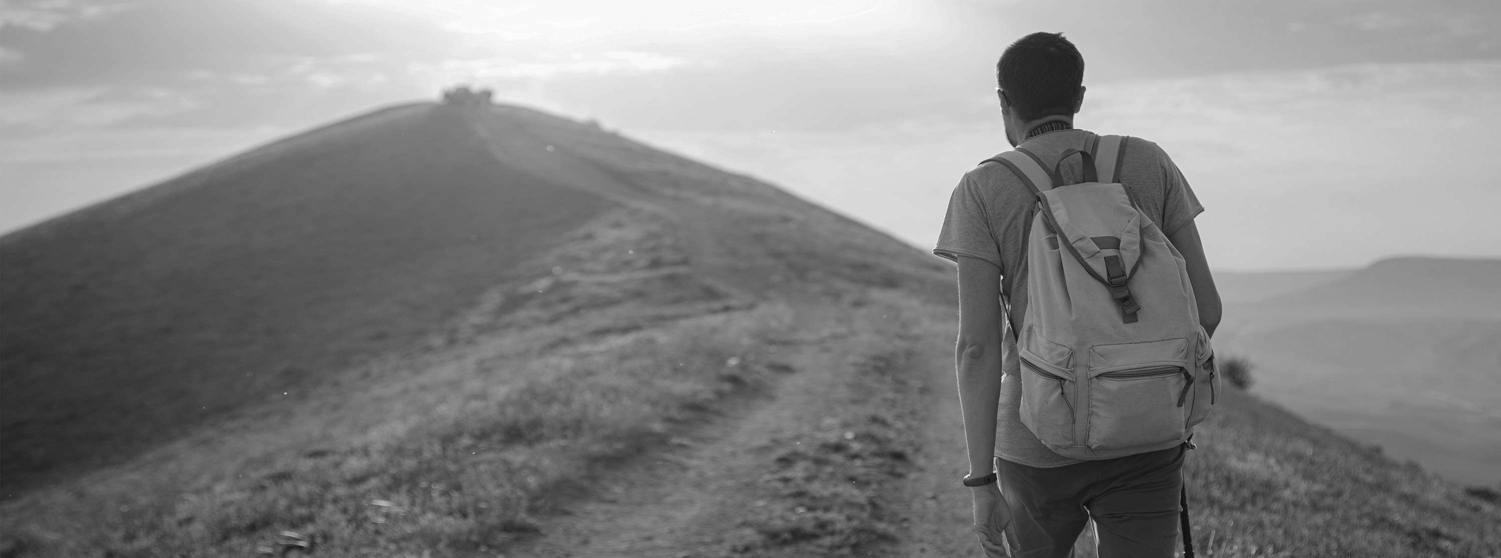 A man with a backpack on his way to the summit of a mountain – in the foreground, the slogan: Ready? Steady! GROW.