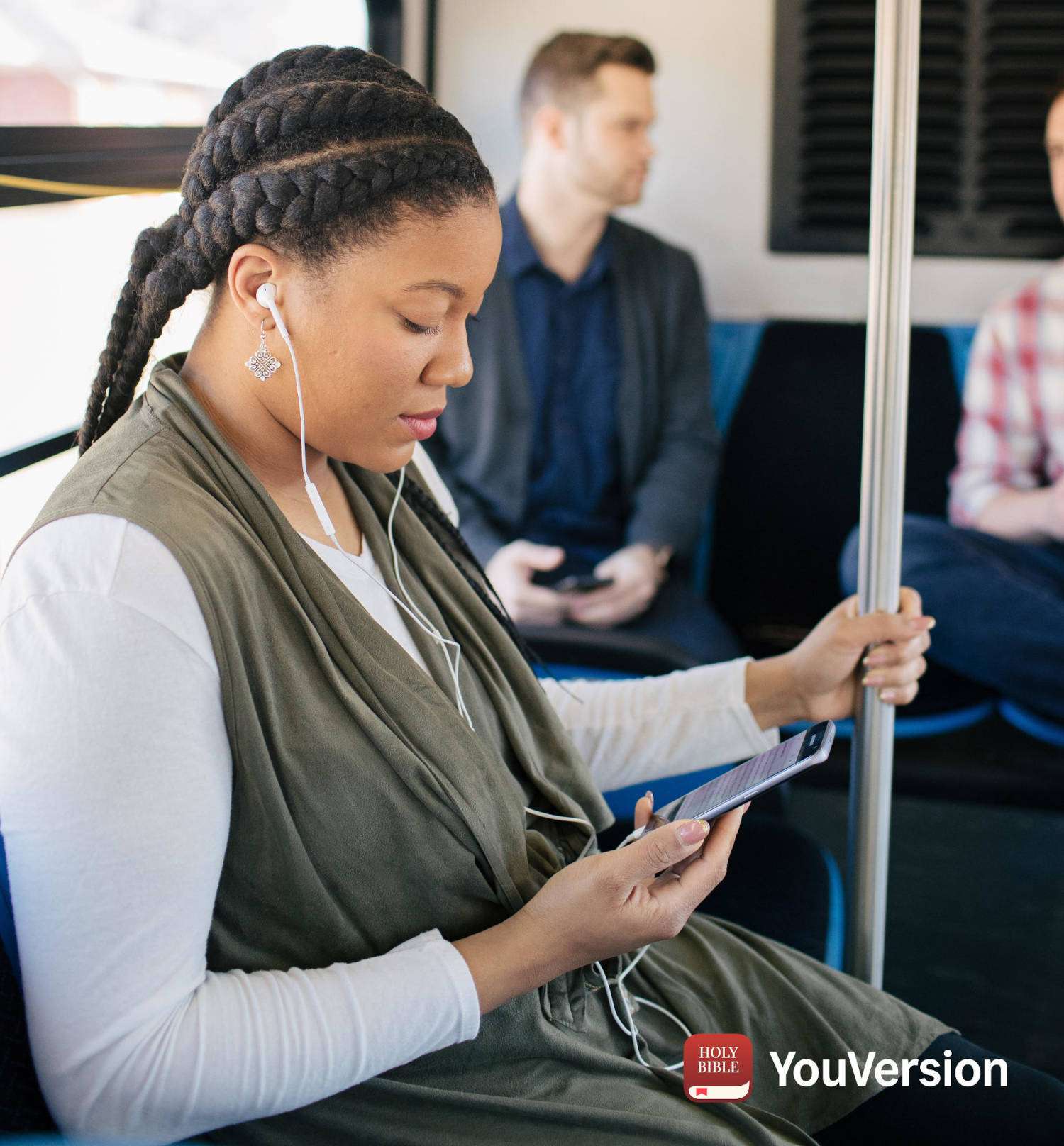 A woman on a train reading the Bible on her smartphone