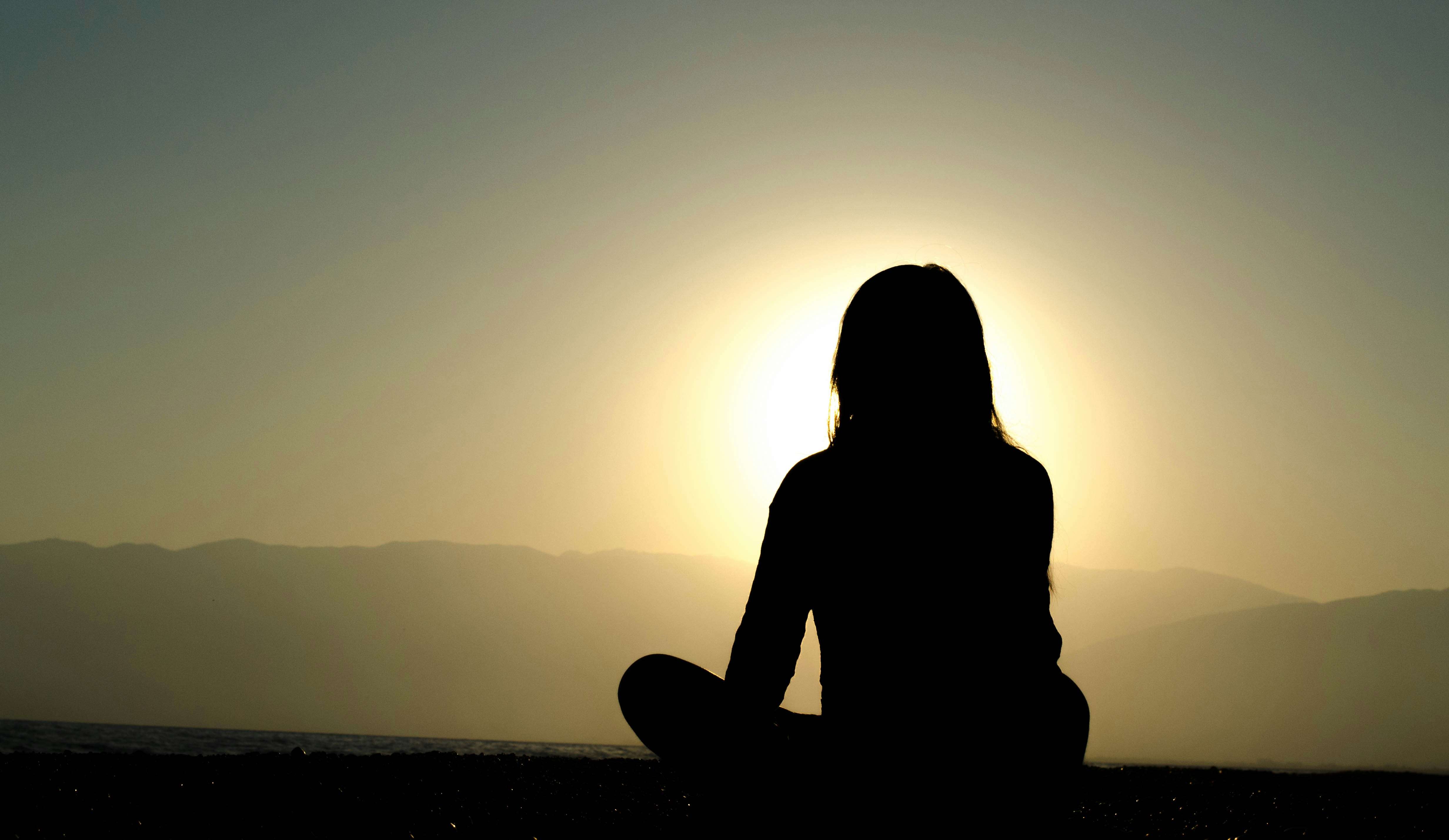 Silhouette of a seated woman blocking the sun.